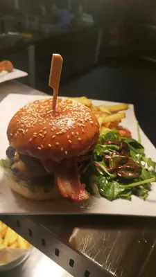 a hamburger and french fries on a plate at The Greyhound Pub in Tibenham