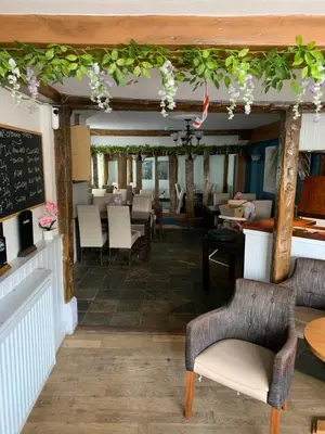 a dining room with tables and chairs and a chalkboard at Stay and Relax at The Yew Tree in Manuden