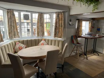 a dining room with a table and chairs and windows at Stay and Relax at The Yew Tree in Manuden
