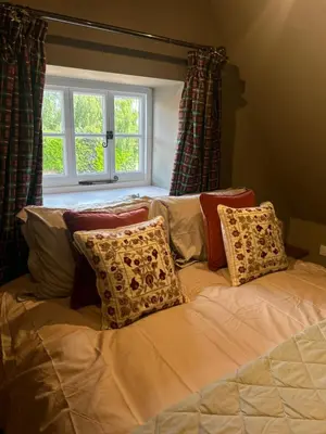 a bed with pillows on it with a window at Trowel and Hammer Flat 1 in Cotton