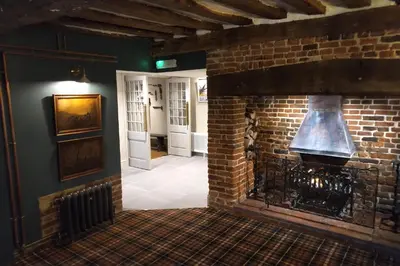 a brick fireplace in a room with a stove at Trowel and Hammer Flat 1 in Cotton
