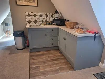 a small kitchen with a counter and a table at Trowel and Hammer Flat 1 in Cotton
