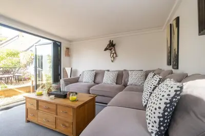a living room with a couch and a table at 5 Burrells Cottages in Leiston