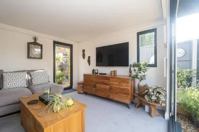 a living room with a couch and a tv at 5 Burrells Cottages in Leiston