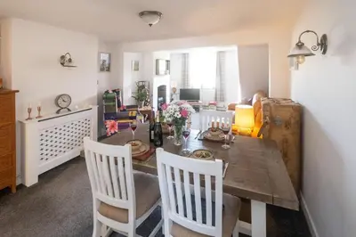 a dining room with a wooden table and chairs at 5 Burrells Cottages in Leiston