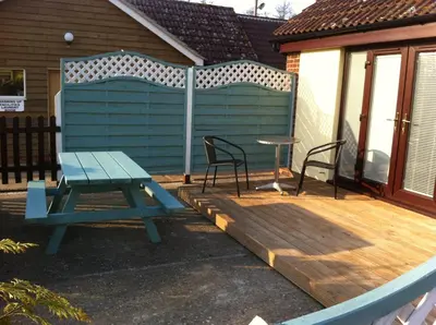 a blue picnic table and chairs on a deck at Annexe at Gosfield Lake in Gosfield