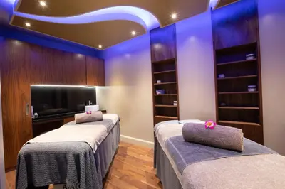 two beds in a room with purple lighting at Down Hall Hotel in Bishops Stortford