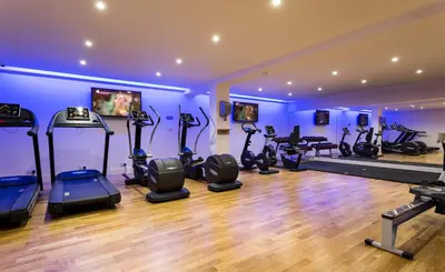 a gym with treadmills and exercise equipment in a room at Down Hall Hotel in Bishops Stortford