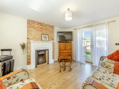 a living room with a couch and a fireplace at Cathedral View Farmhouse in Ely