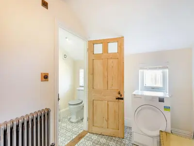 a bathroom with a toilet and a wooden door at Cathedral View Farmhouse in Ely