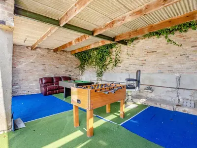 a ping pong table in the middle of a room at Cathedral View Farmhouse in Ely