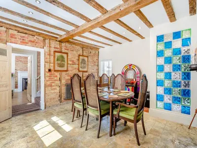 a dining room with a brick wall and a table and chairs at Cathedral View Farmhouse in Ely