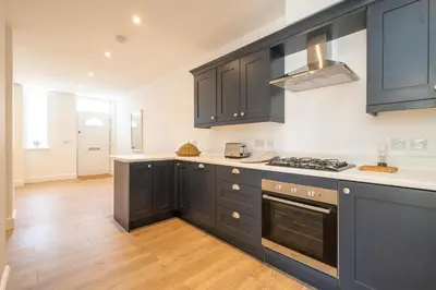 a kitchen with black cabinets and a stove top oven at Volunteer Lodge, Leiston - Aldeburgh Coastal Cottages in Leiston