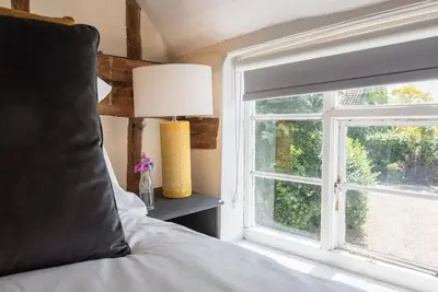 a bedroom with a bed and a window at Anchor Cottage, Orford in Woodbridge