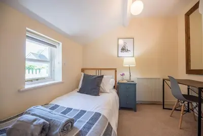 a bedroom with a bed and a desk and a window at Anchor Cottage, Orford in Woodbridge