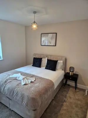 a bedroom with a bed with a robe on it at Contractors l FreeParking l Station l Students in Colchester