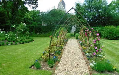 a garden with a arch and a bunch of flowers at Orchard View in Bungay
