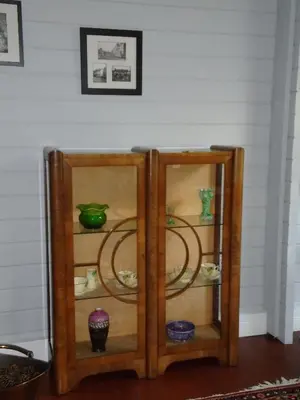 a glass cabinet with bowls and vases on it at Orchard View in Bungay