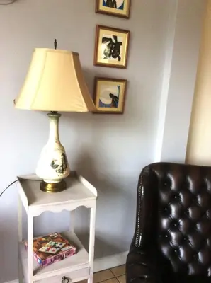 a lamp on a white table next to a chair at Sam's Stable in Bungay