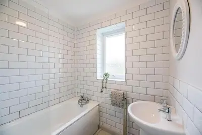 a white bathroom with a tub and a sink at Beautiful Aldeburgh Coastal Getaway in Aldeburgh