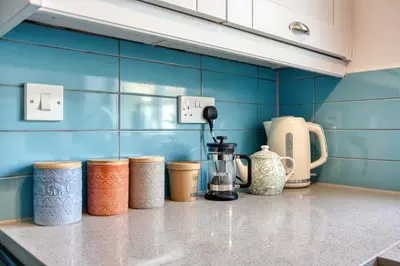 a kitchen counter with different colored containers on it at Beautiful Aldeburgh Coastal Getaway in Aldeburgh