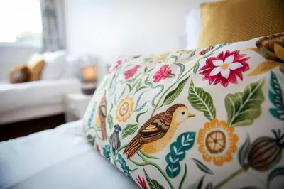 a pillow with a bird on it sitting on a couch at Pheasants Rest in Bar Hill