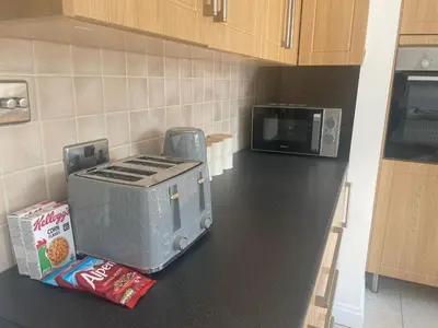 a kitchen counter with a toaster oven and a microwave at Pheasants Rest in Bar Hill