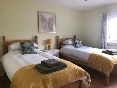 a bedroom with two beds with towels on them at Barn Owl Lodge with Hot Tub - Adults Only in Lackford