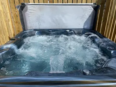 a hot tub filled with water in a container at Barn Owl Lodge with Hot Tub - Adults Only in Lackford