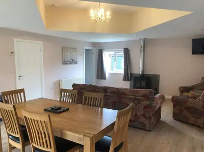 a living room with a wooden table and a couch at Barn Owl Lodge with Hot Tub - Adults Only in Lackford