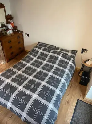 a bed with a black and white plaid comforter in a bedroom at The old wash house in Denver