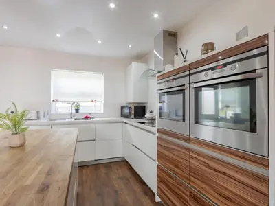a kitchen with white cabinets and stainless steel appliances at Comfortable home Langdon Hills - Pass the Keys in Basildon