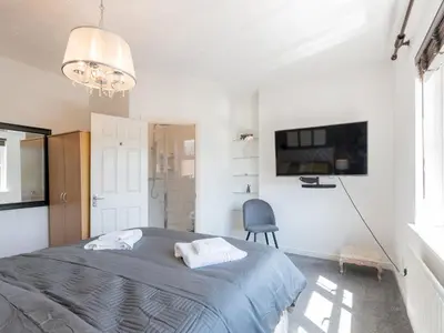 a bedroom with a bed and a tv and a chair at Comfortable home Langdon Hills - Pass the Keys in Basildon