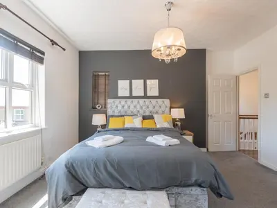 a bedroom with a large bed with yellow pillows at Comfortable home Langdon Hills - Pass the Keys in Basildon