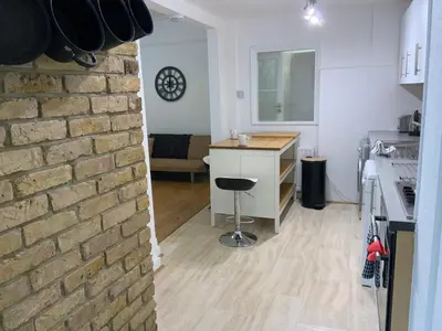 a kitchen and living room with a brick wall at Right by Leigh Broadway Private Garden large ground fl apt in Southend-on-Sea