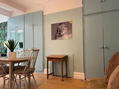 a living room with a table and a chair at Right by Leigh Broadway Private Garden large ground fl apt in Southend-on-Sea