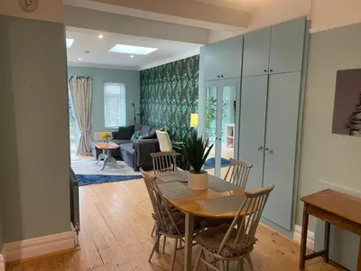a dining room and living room with a table and chairs at Right by Leigh Broadway Private Garden large ground fl apt in Southend-on-Sea