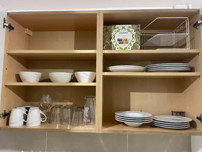 a cabinet filled with plates and bowls and dishes at Right by Leigh Broadway Private Garden large ground fl apt in Southend-on-Sea