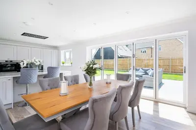 a kitchen and dining room with a wooden table and chairs at Kestral House in Eye