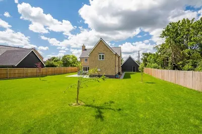 a yard with a house and a fence at Kestral House in Eye
