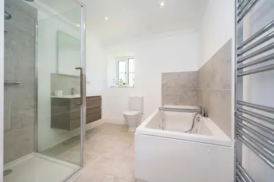a bathroom with a tub and a toilet and a shower at Kestral House in Eye