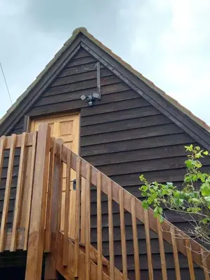 a house with a wooden door and a wooden fence at Rustic Retreat Guest Lodge in Littleport