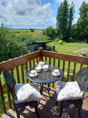 a table and two chairs on a wooden deck at Rustic Retreat Guest Lodge in Littleport