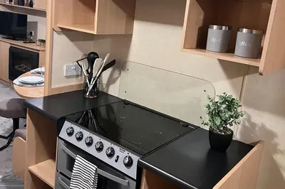 a kitchen with a black stove top oven at 3 Bedroom Caravan - Sleeps 8 - Parking Wifi Pool in Clacton-on-Sea