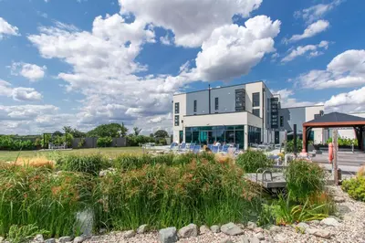 a large white building with a garden in front of it at Glass House Retreat in Puddle Dock