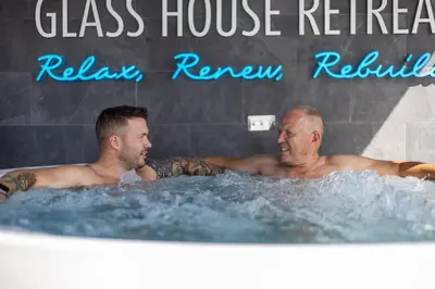 two men in the hot tub at a glass house restaurant at Glass House Retreat in Puddle Dock