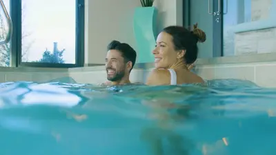 a man and woman in a hot tub at Glass House Retreat in Puddle Dock