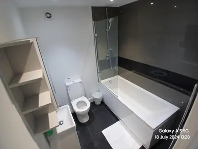 a small bathroom with a shower and a toilet at Hornchurch House - Jackson Close in Harold Wood