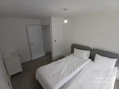 a bedroom with a bed with white sheets and pillows at Hornchurch House - Jackson Close in Harold Wood