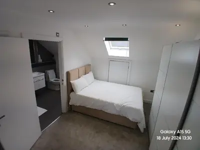 a small bedroom with a bed and a bathroom at Hornchurch House - Jackson Close in Harold Wood